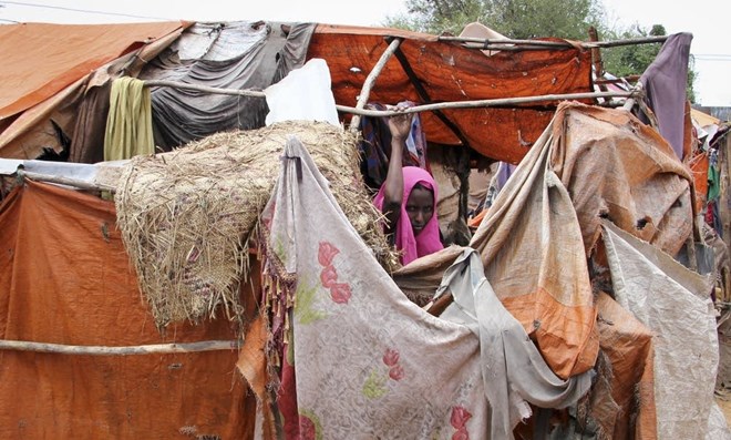 In this photo taken Wednesday, Nov. 16, 2016, Somali refugee and mother of six Madino Dhurow stands by her makeshift shelter in the Daryeel camp for the displaced. Farah Abdi Warsameh | AP 2016